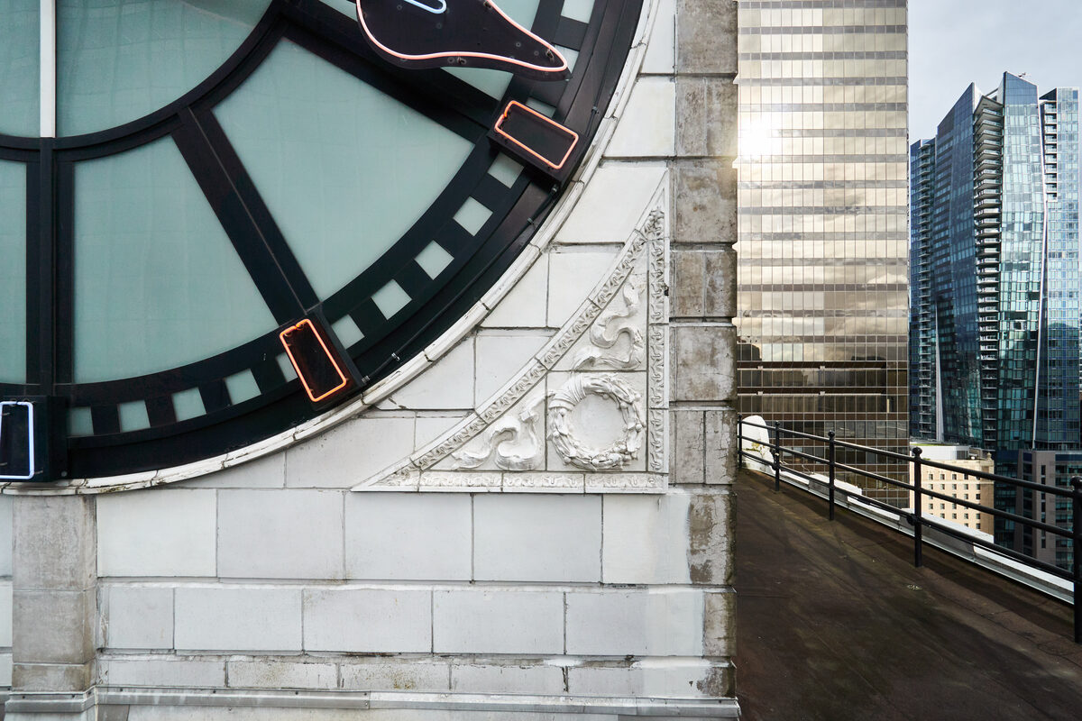 Corner detail of the clock tower showing terracotta rosette and carved stone surround