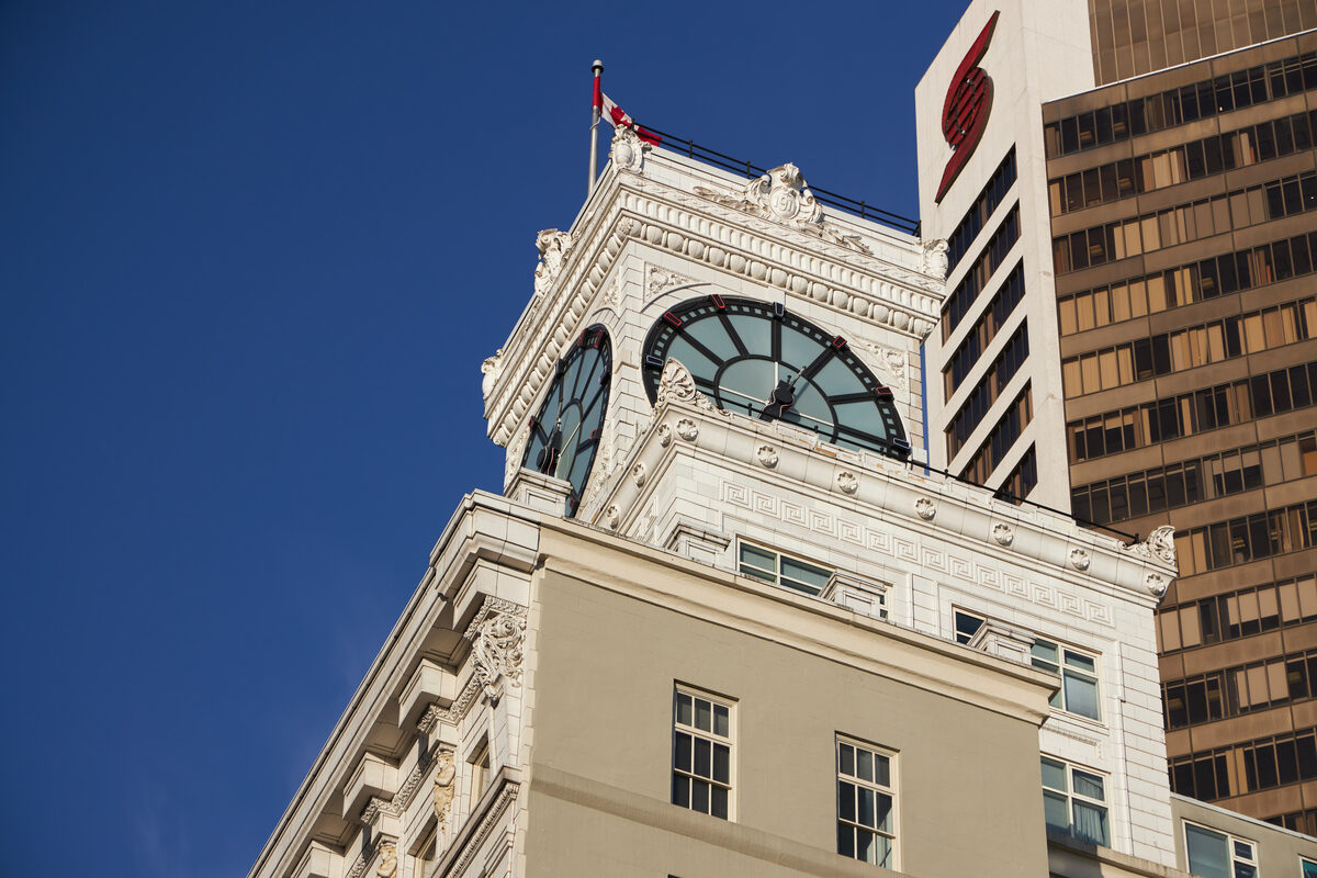 The Vancouver Block clock tower rising against a clear blue sky, viewed from Granville Street